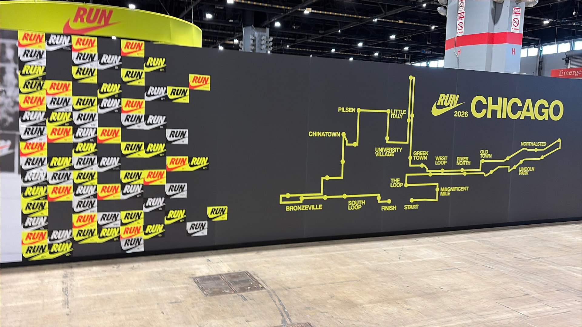 The Nike run wall at the 2026 expo, a grid of RUN signs beside a yellow neighborhood map of the 2026 Chicago Marathon route