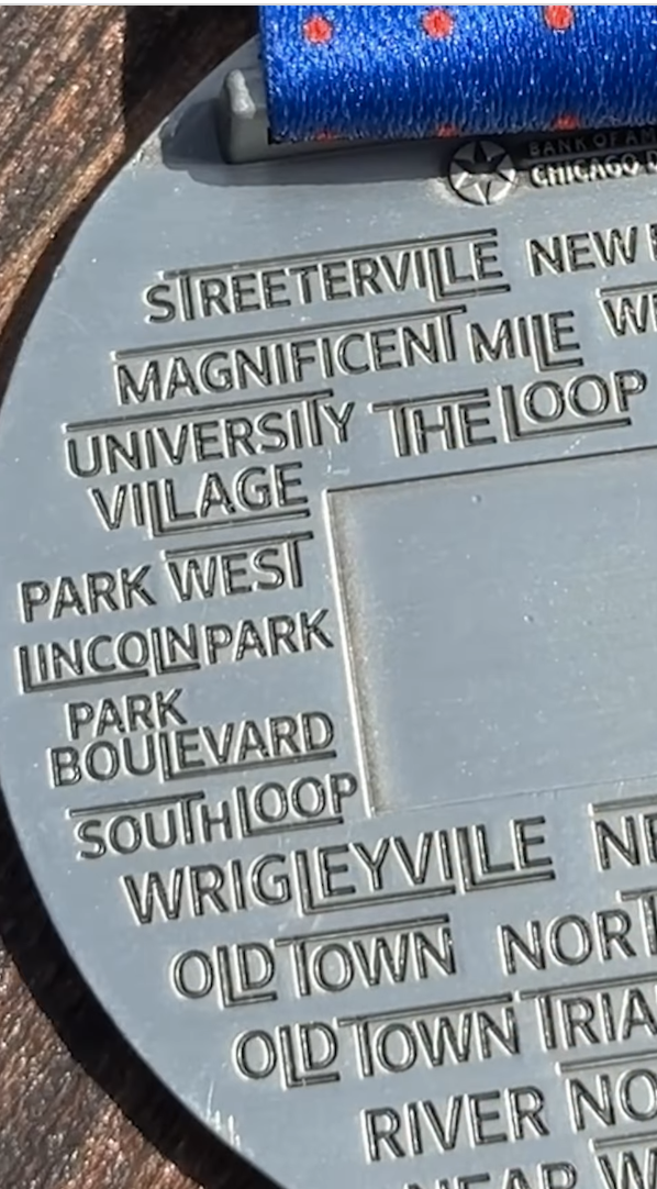 Back of the 2026 Chicago Marathon medal showing the 29 neighborhoods engraved by name