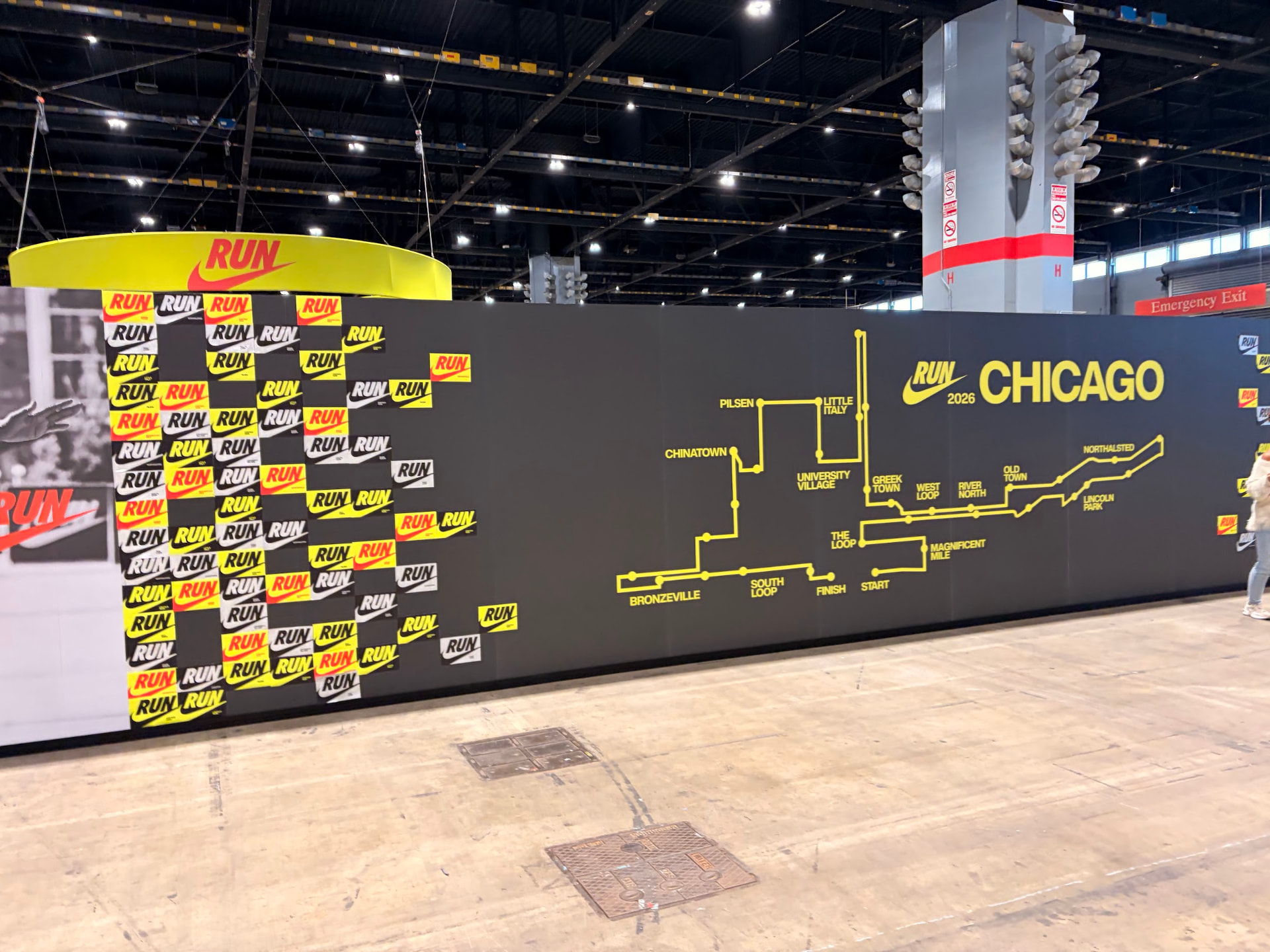 Wide view of the expo hall floor at the Abbott Health and Fitness Expo, polished concrete stretching toward the Nike run wall