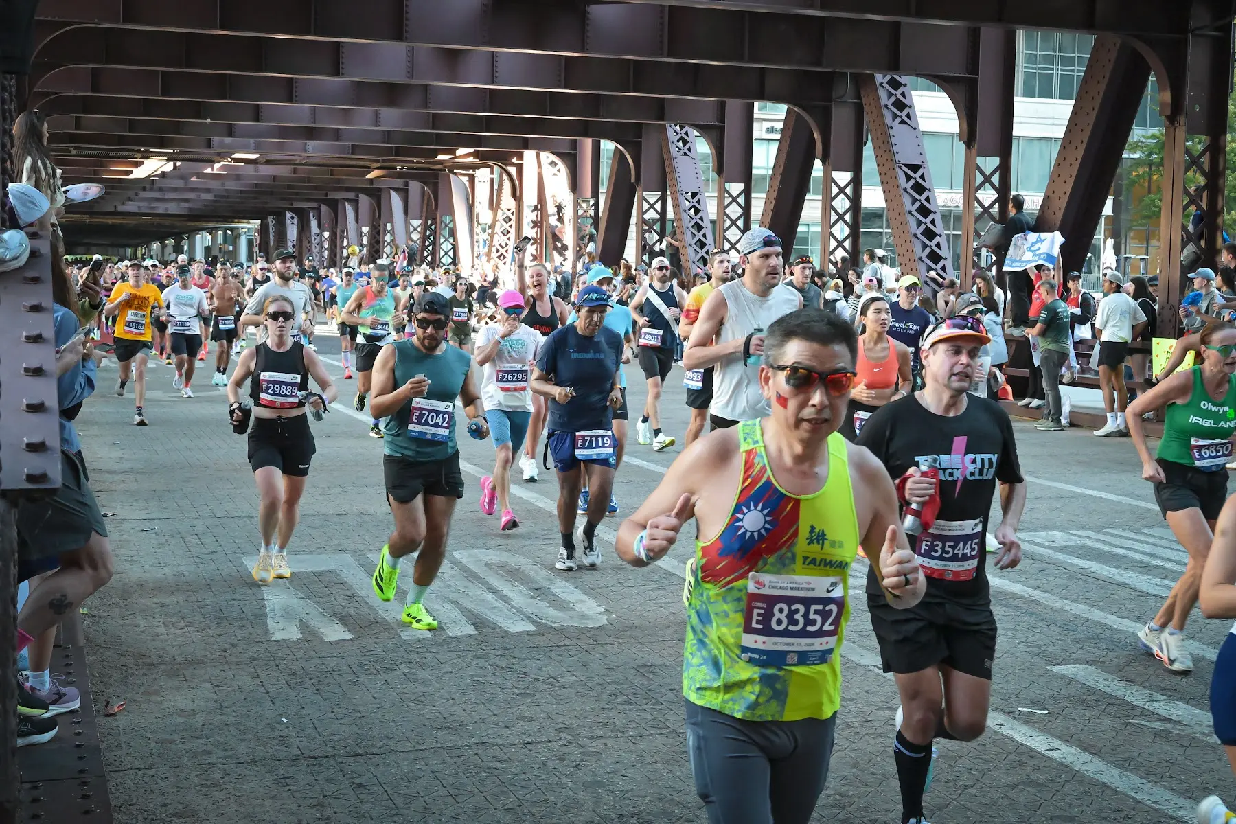 Runners crossing a steel bridge over the Chicago River during the middle miles of the Chicago Marathon