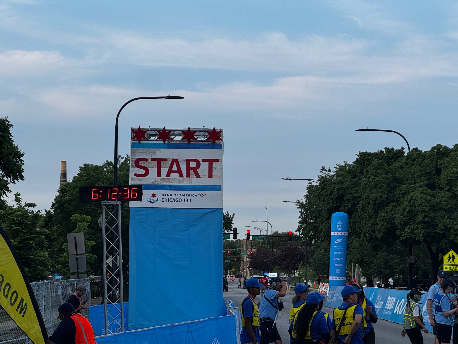 Chicago 13.1 start line arch at Garfield Park with clock reading 6:12 and corral staff nearby