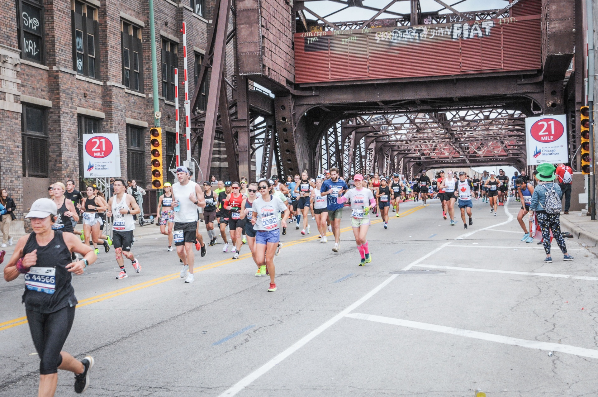 Runners crossing a bridge at mile 21 during the Chicago Marathon through Chinatown